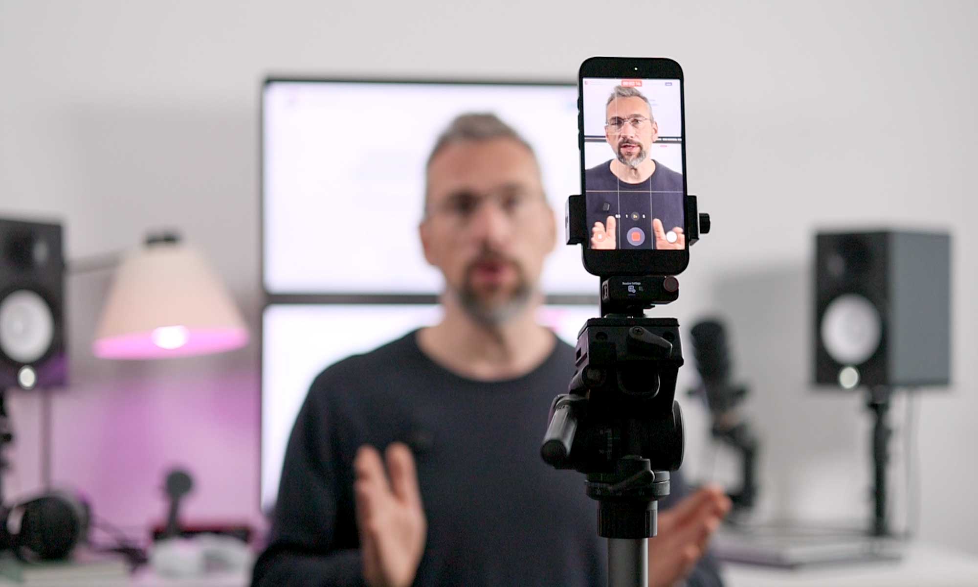 Martin Kulawik bei einer Videoaufnahme im Studio, im Vordergrund ein Smartphone auf einem Stativ.